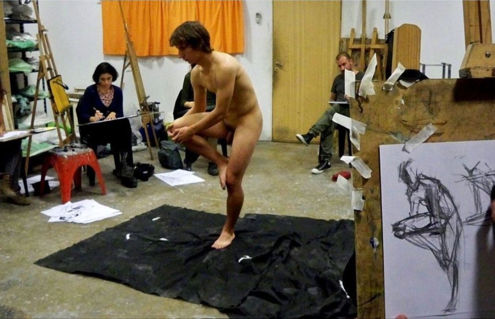 Naked women pose an artist
