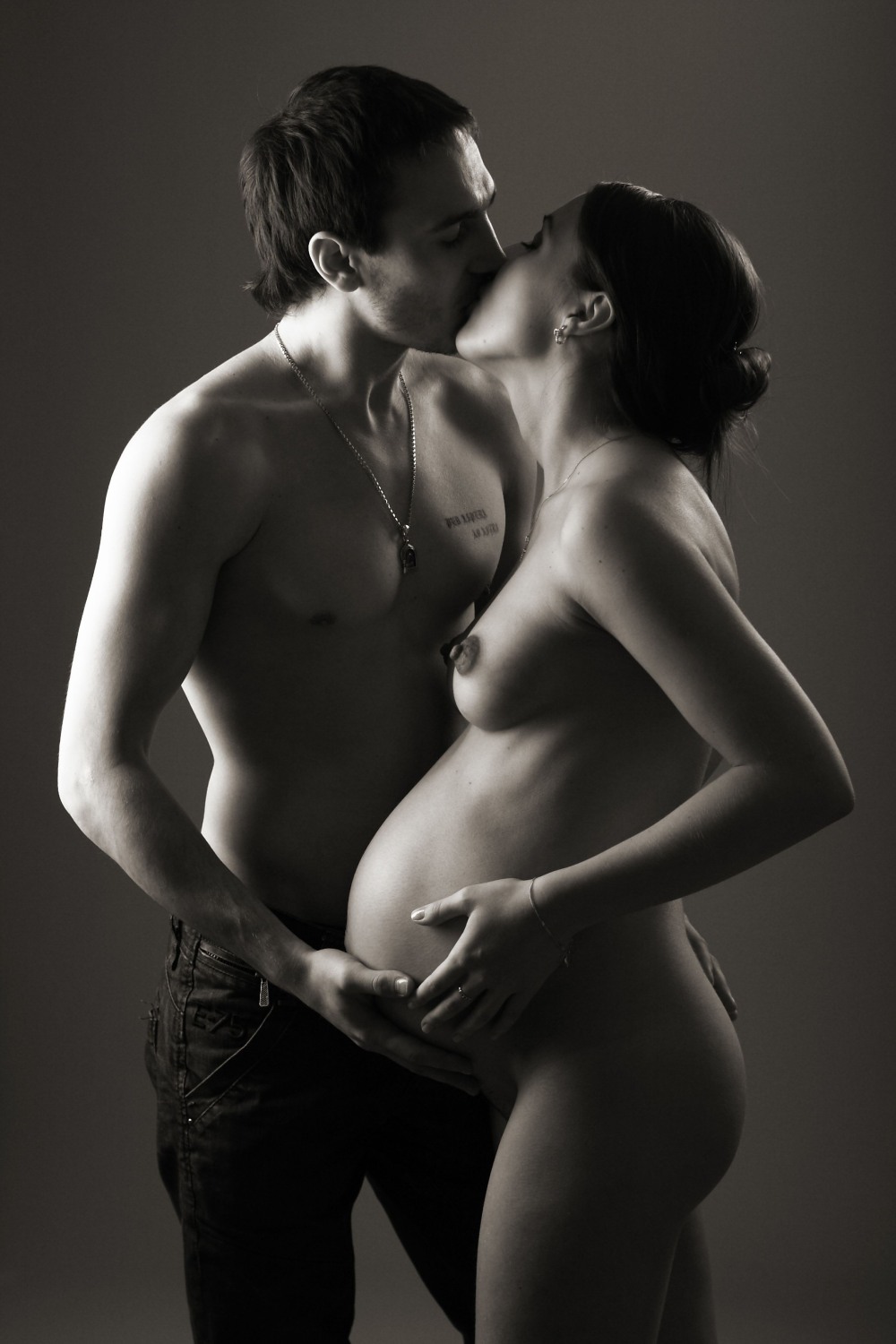 Erotic photo shoot of a pregnant woman with her husband
