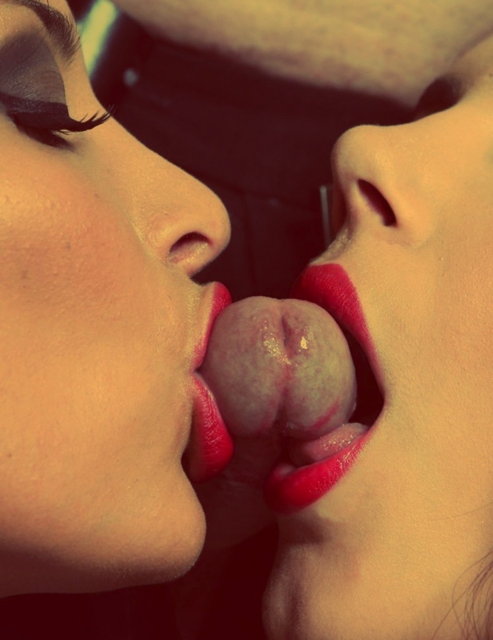 Two girls lick testicles